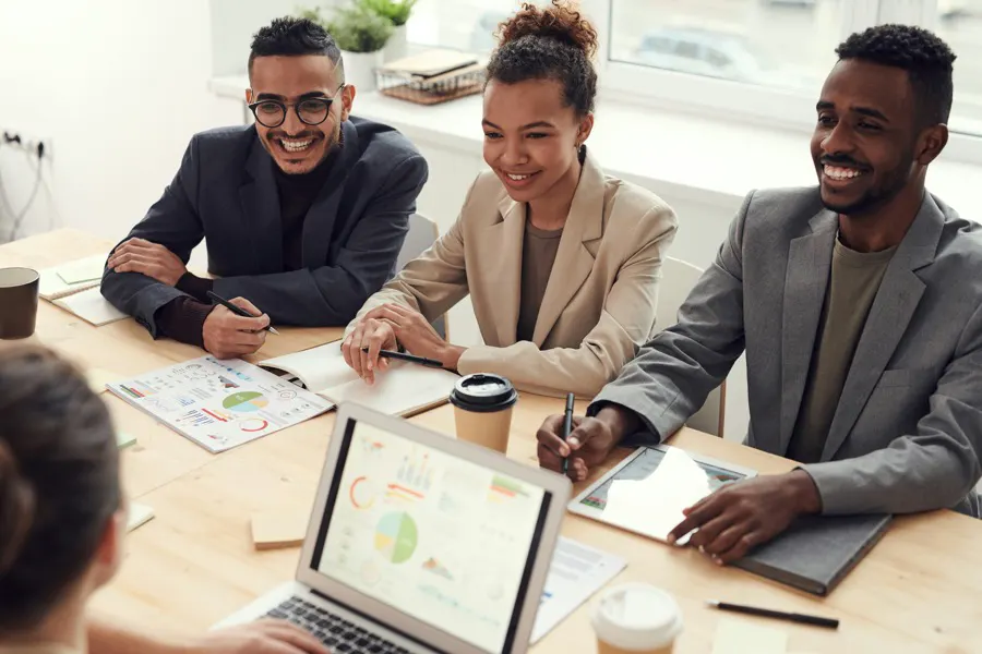 A small Guyanese business team planning at a table